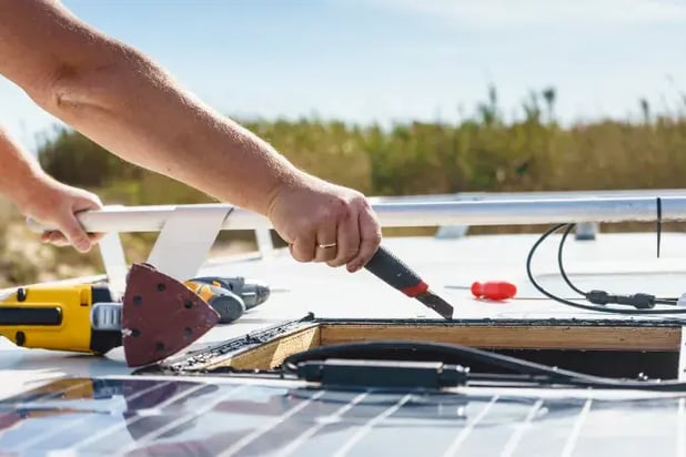 a worker fitting solar panels powered by a solar battery to show their advantages.