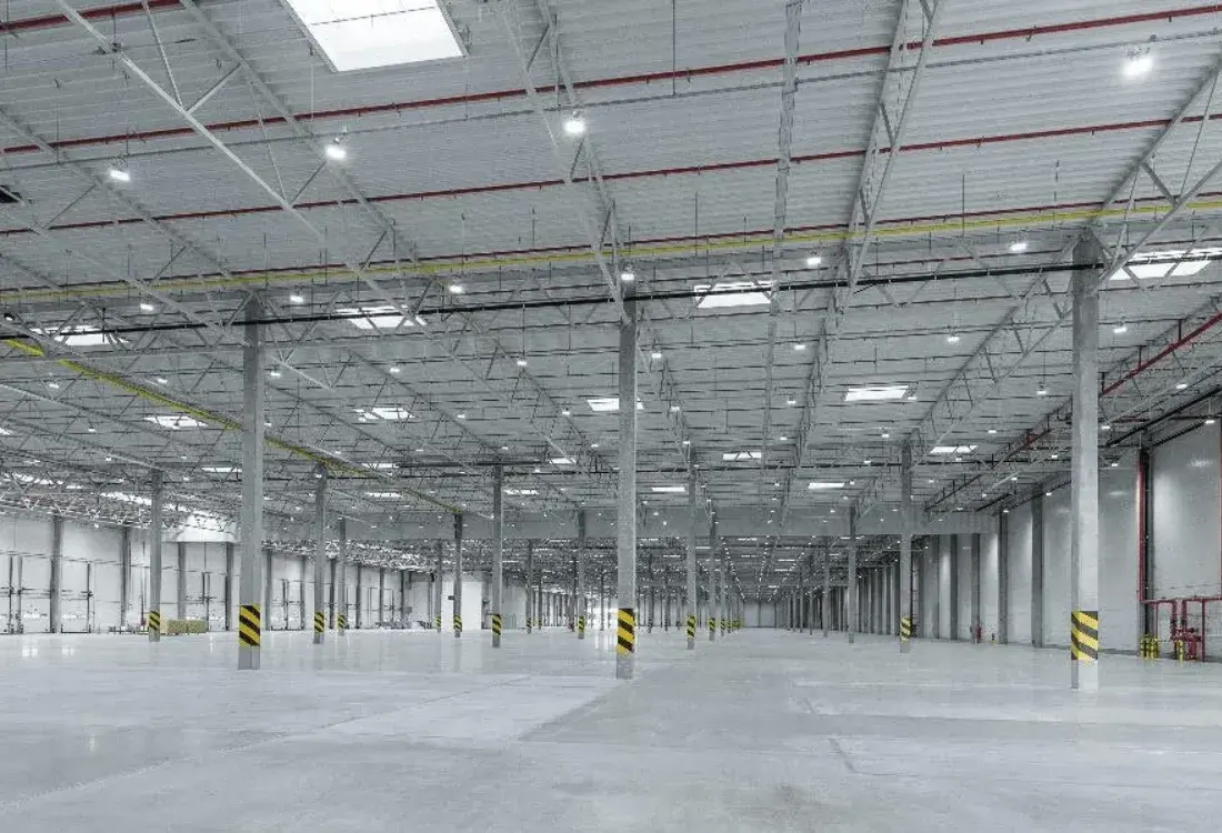 A warehouse full of panels with lights on after undergoing a decision to decide which warehouse lighting was right for their business.